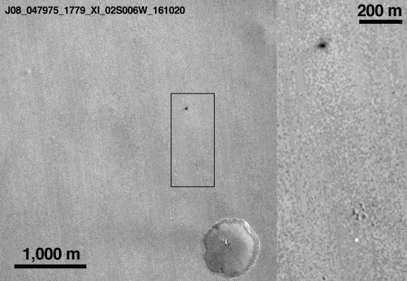 Cráter de Schiaparelli (mancha negra) y el paracaídas (mancha banca) en la imagen tomada por la cámara CTX de MRO (NASA/JPL-Caltech/MSSS).